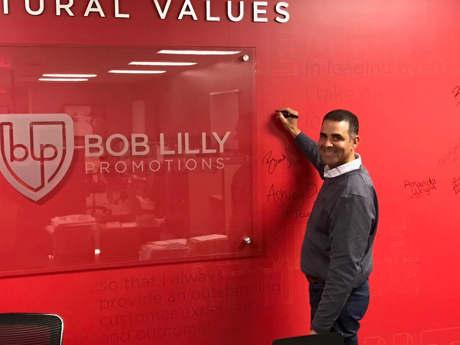 BLP employee signing the Red Wall of company core values at their one-year service milestone celebration in Garland, TX