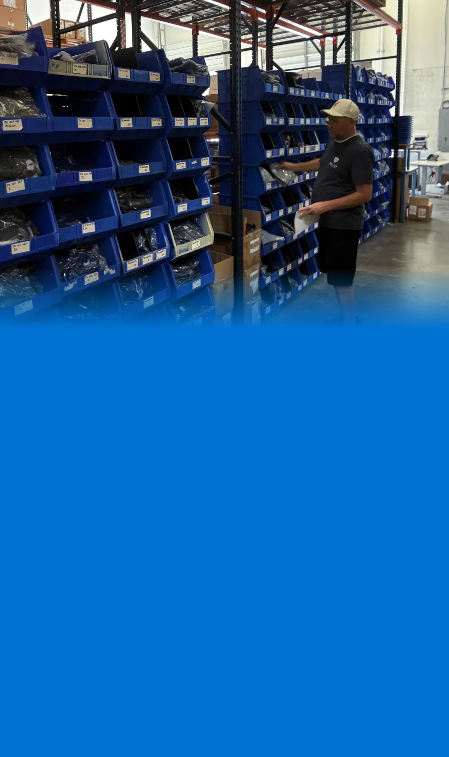 A Bob Lilly Promotions team member picking apparel from labeled bins in the Garland, Texas warehouse