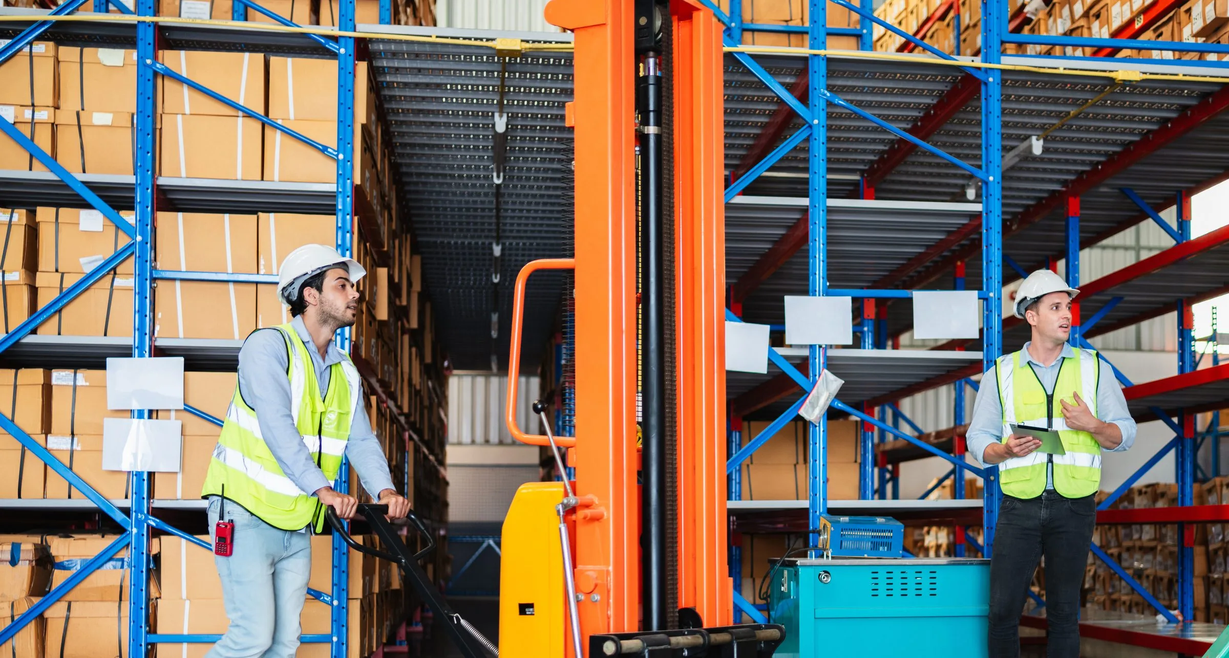 Warehouse team moving palletized goods through racking in a fulfillment operation