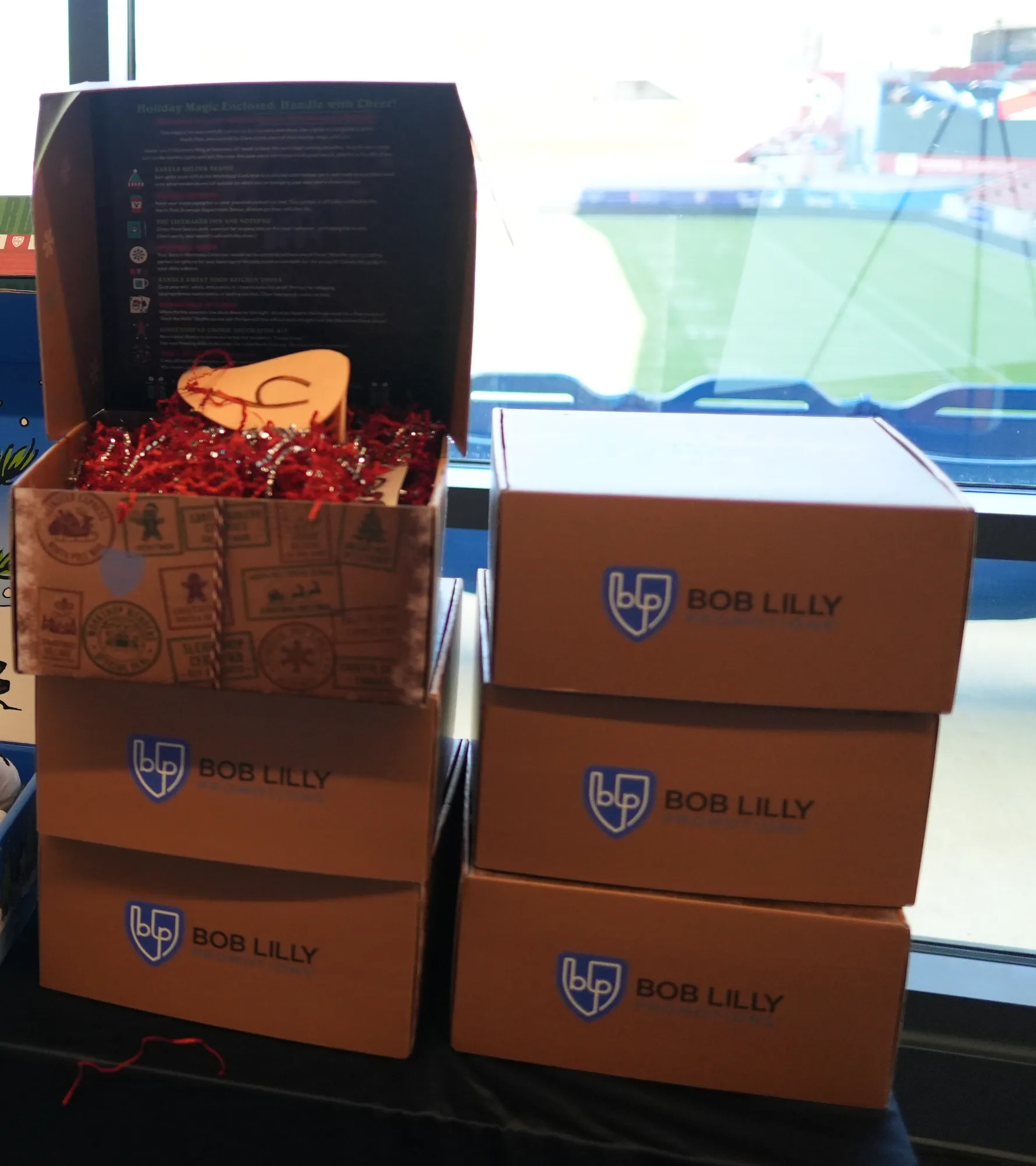 Bob Lilly Promotions branded holiday gift boxes stacked on display beside an open North Pole Express box